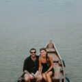 a man and a woman sitting in a boat on the water